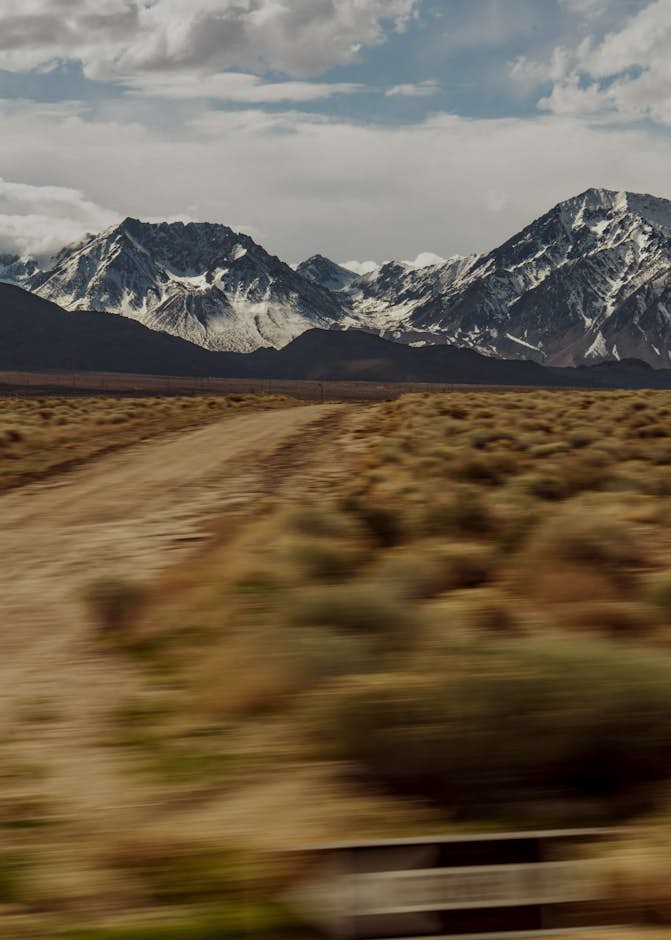 A dirt road with mountains in the background
