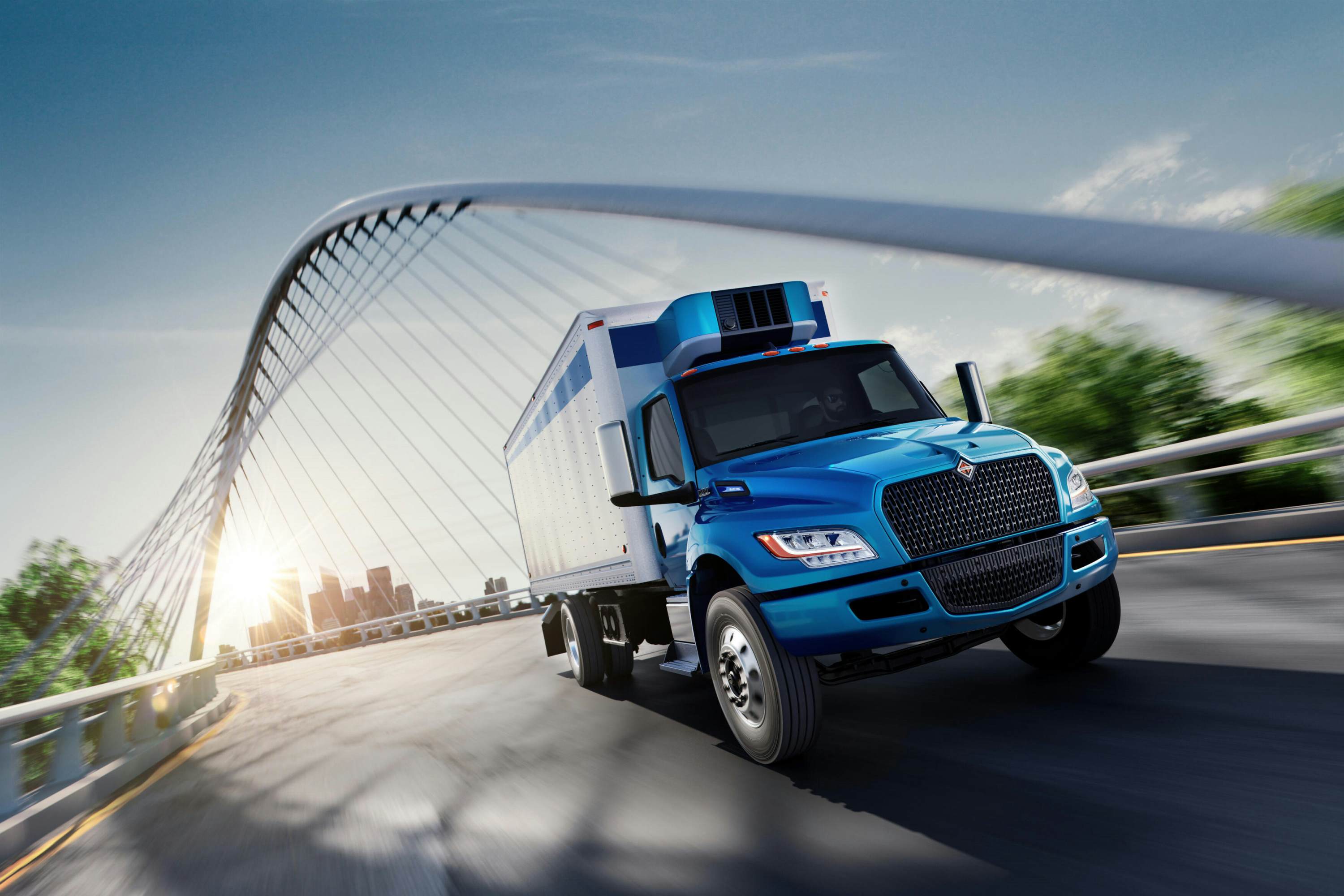 A blue truck driving on a bridge
