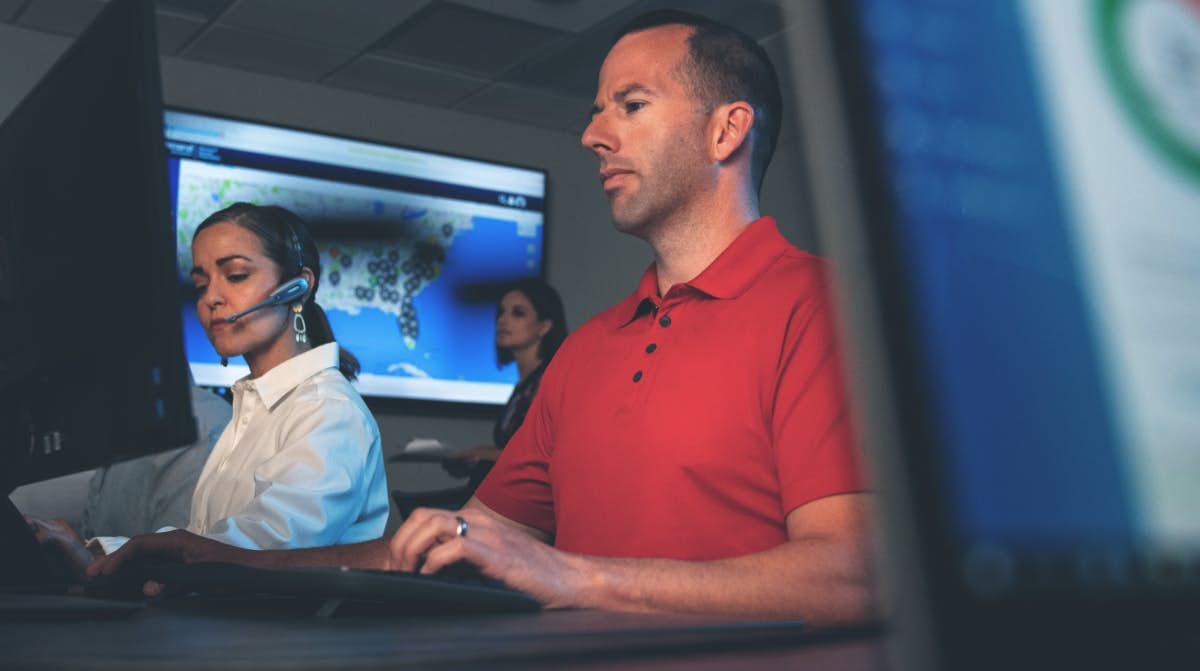 A person and person working at a computer