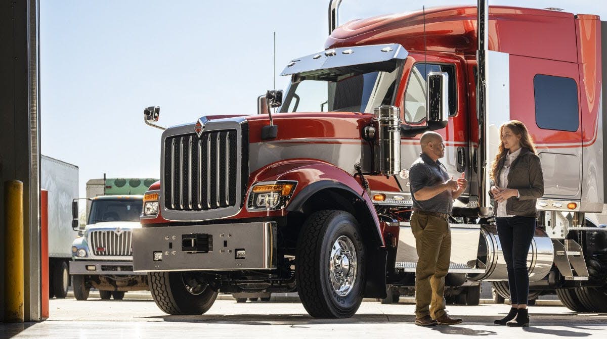 A person and person standing next to a truck