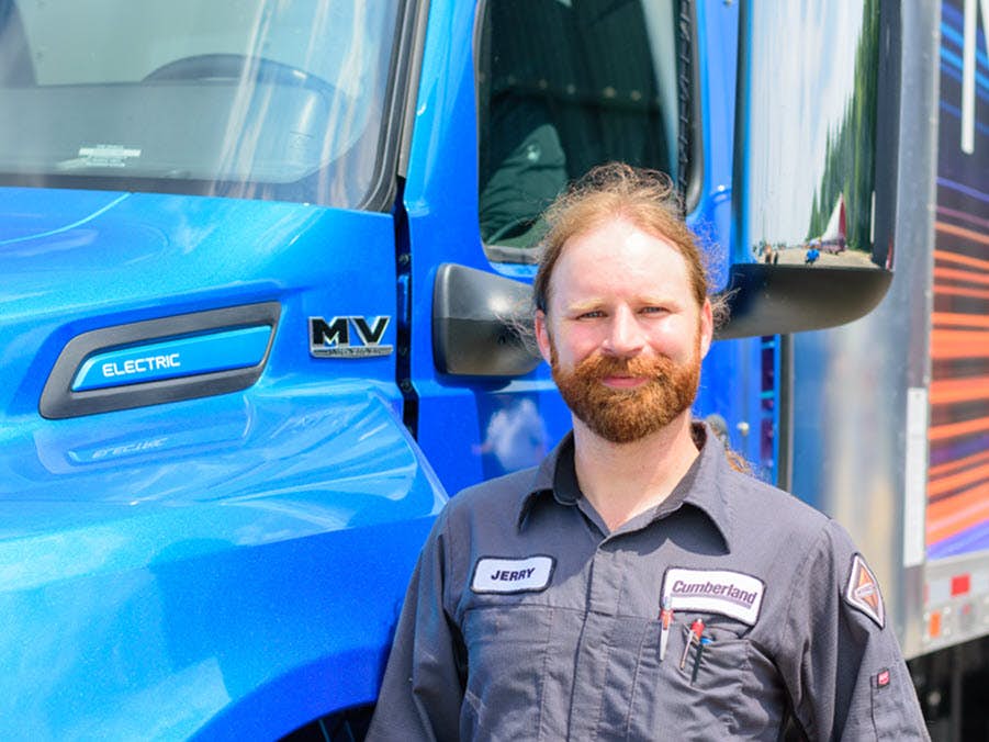 A person standing in front of a blue truck