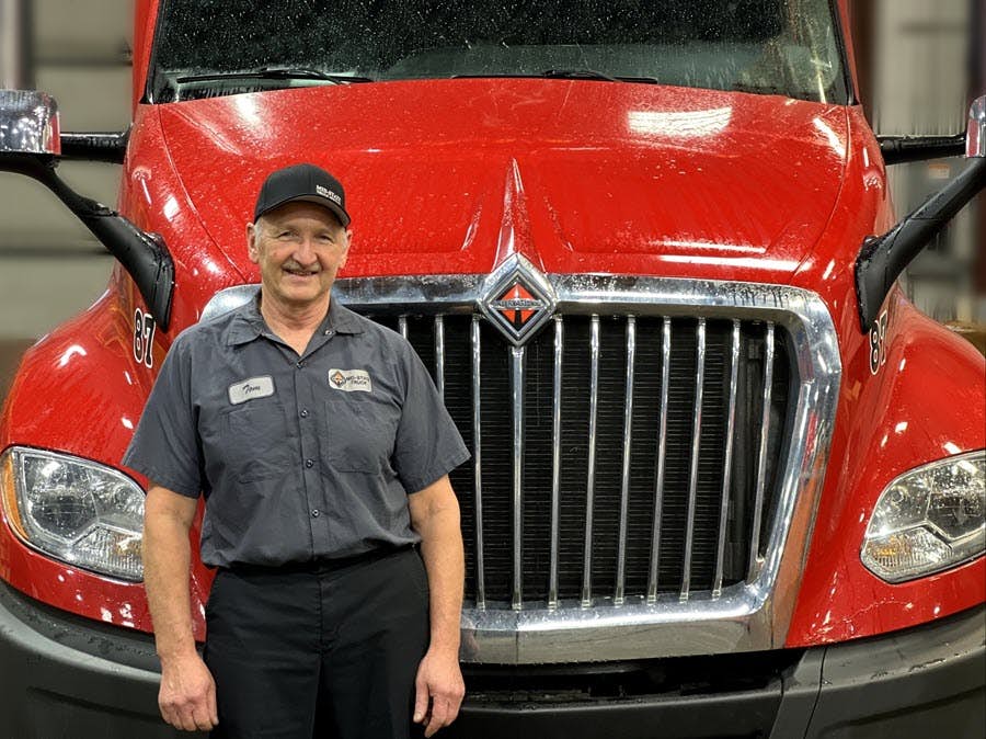 A person standing in front of a red truck