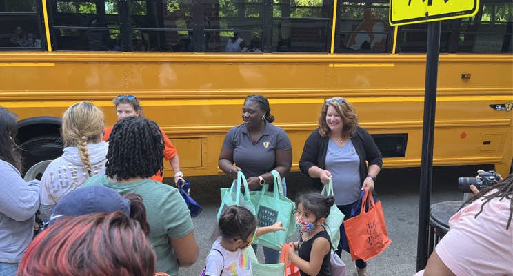 A group of people standing in front of a school bus