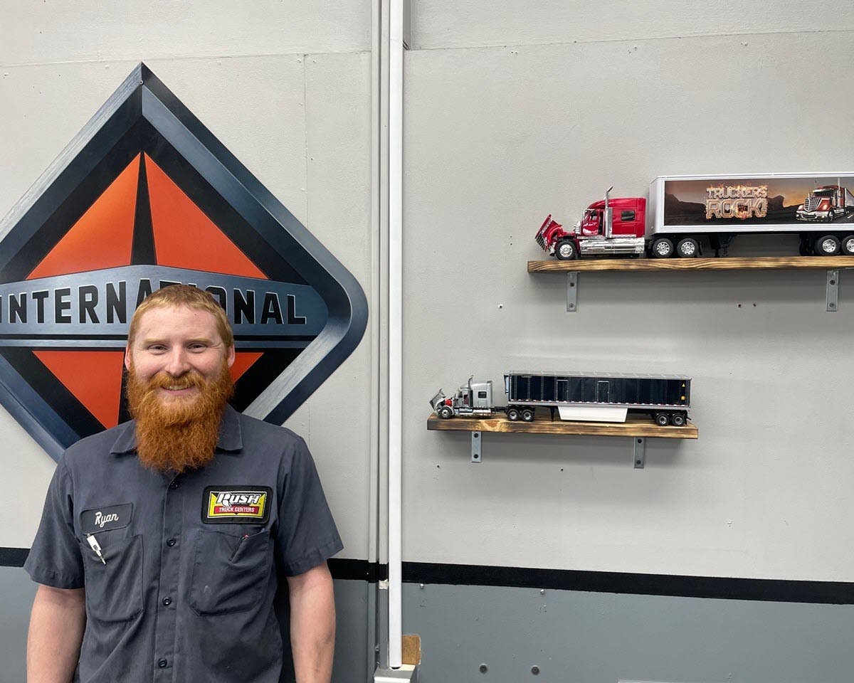 International technician in front of truck models